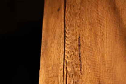Macro perspective capturing a fine vertical fracture line flanked by dense linear wood fibers on a commercial timber face. 