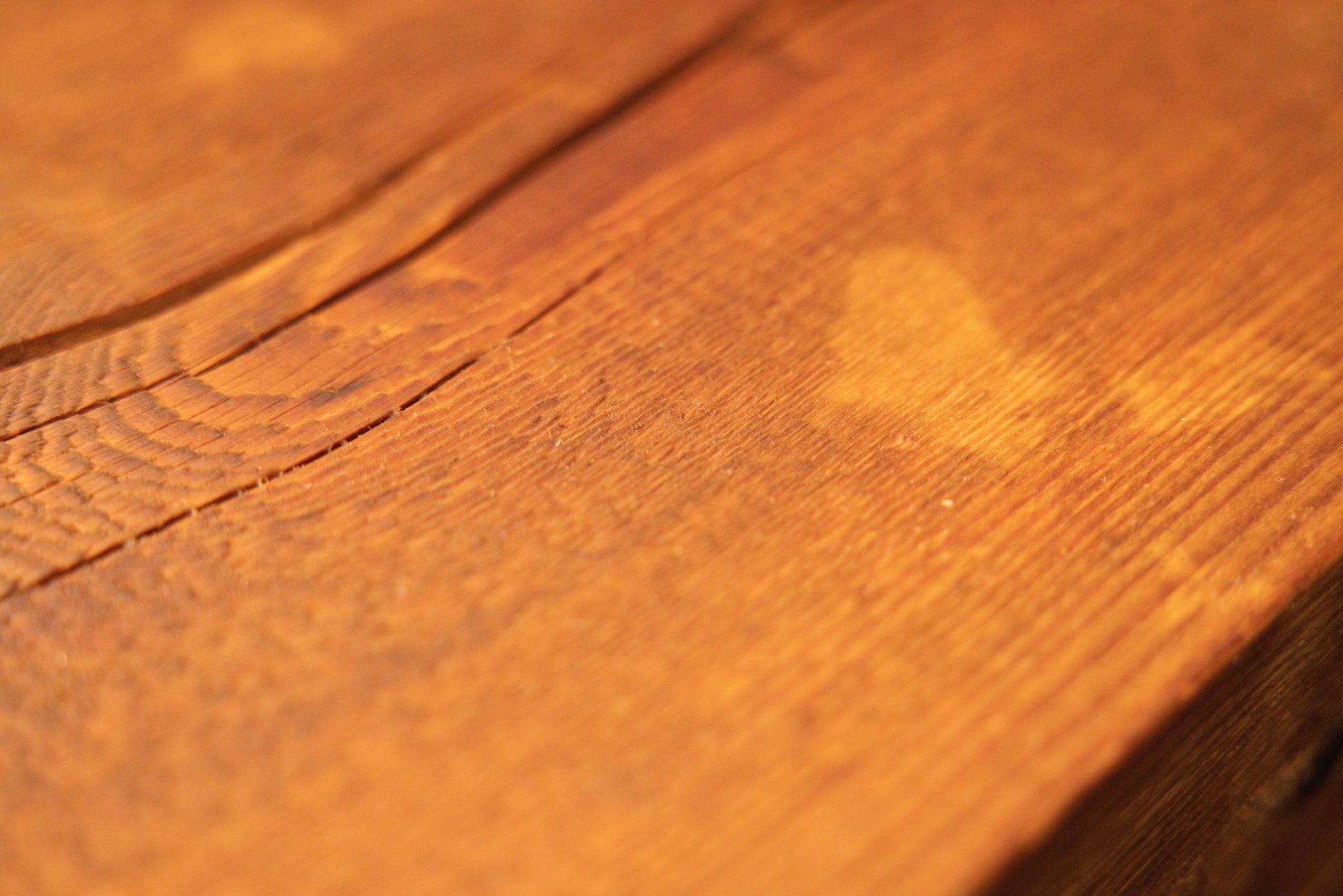 Macro perspective of a climate-stable wooden plank surface showcasing fine grain textures and a lighter color patch. 