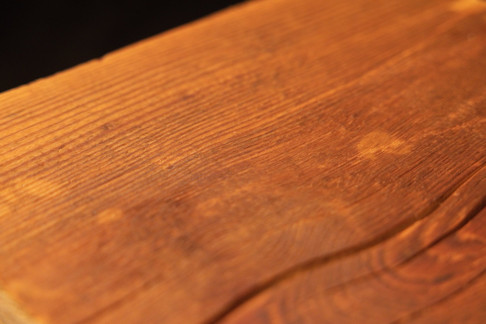 Detailed close-up macro view of smooth grain textures and subtle color variations across the flat surface of a wooden plank. 