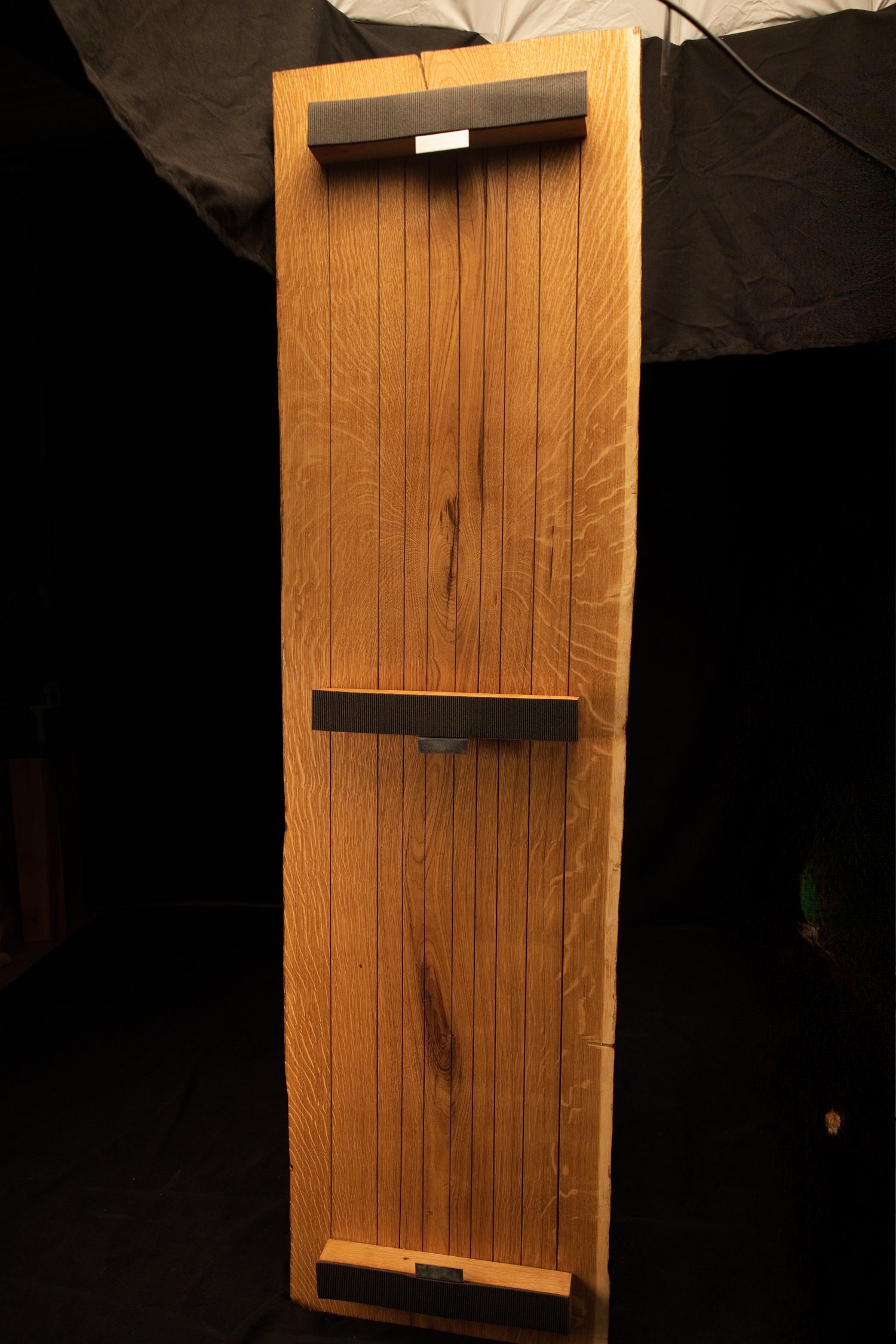 Full back elevation of a custom oak frame featuring three dark horizontal mounting crossbars secured across vertical slats.