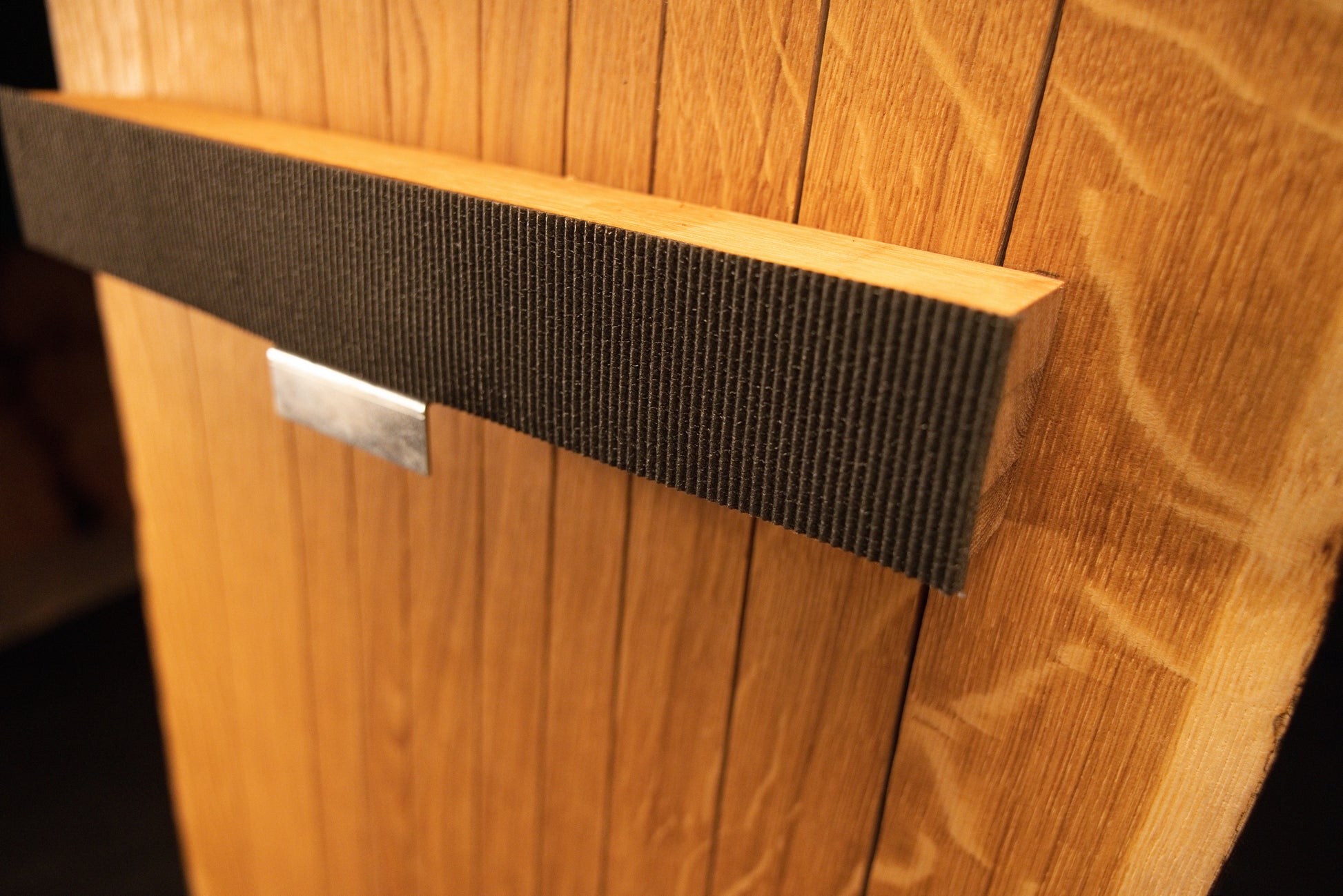 Macro perspective highlighting the textured durable woven fabric strap wrapped around the horizontal wooden support bracket.