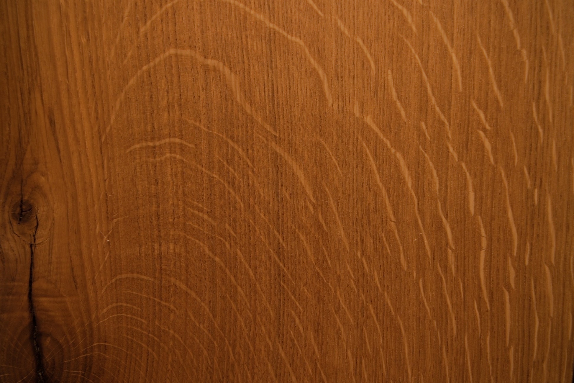 Extreme macro photography capturing striking medullary ray patterns across the rich golden face of the custom oak timber panel.