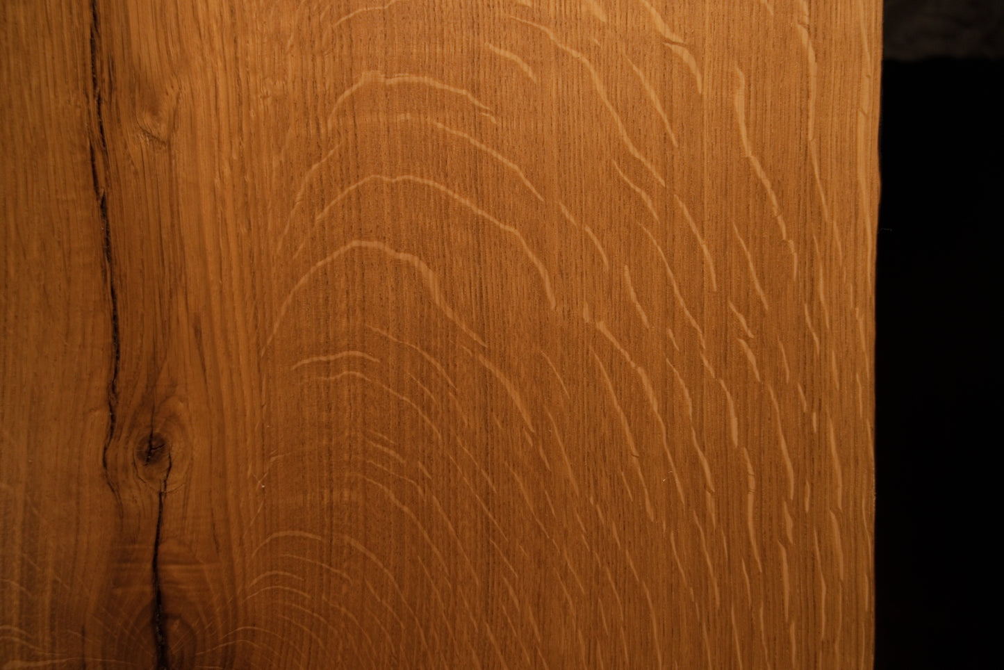 Macro view of natural chatoyancy and shimmering light reflection across the quartersawn medullary rays of the premium oak board.