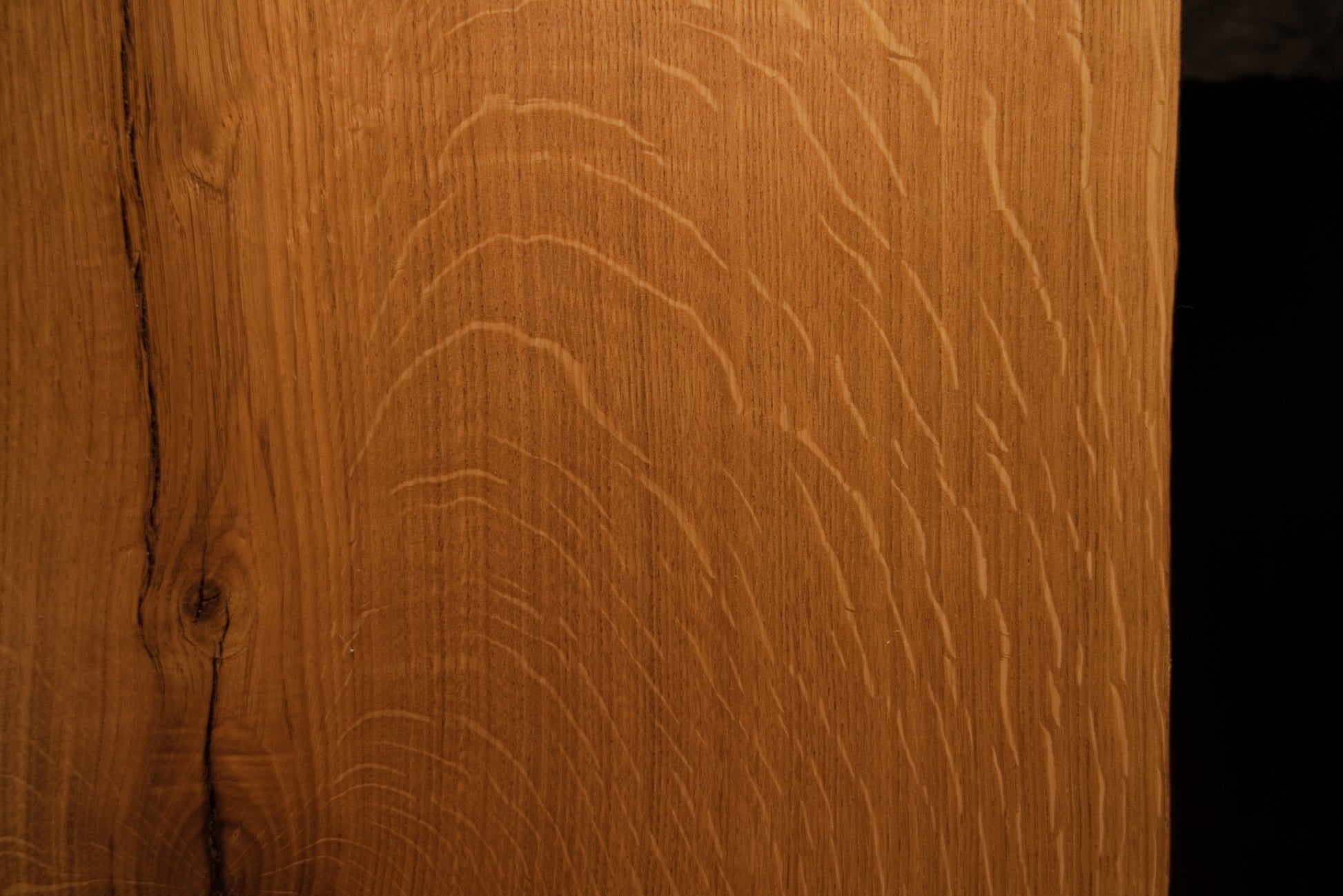 Macro view of natural chatoyancy and shimmering light reflection across the quartersawn medullary rays of the premium oak board.