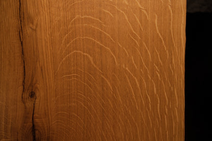 Macro view of natural chatoyancy and shimmering light reflection across the quartersawn medullary rays of the premium oak board.