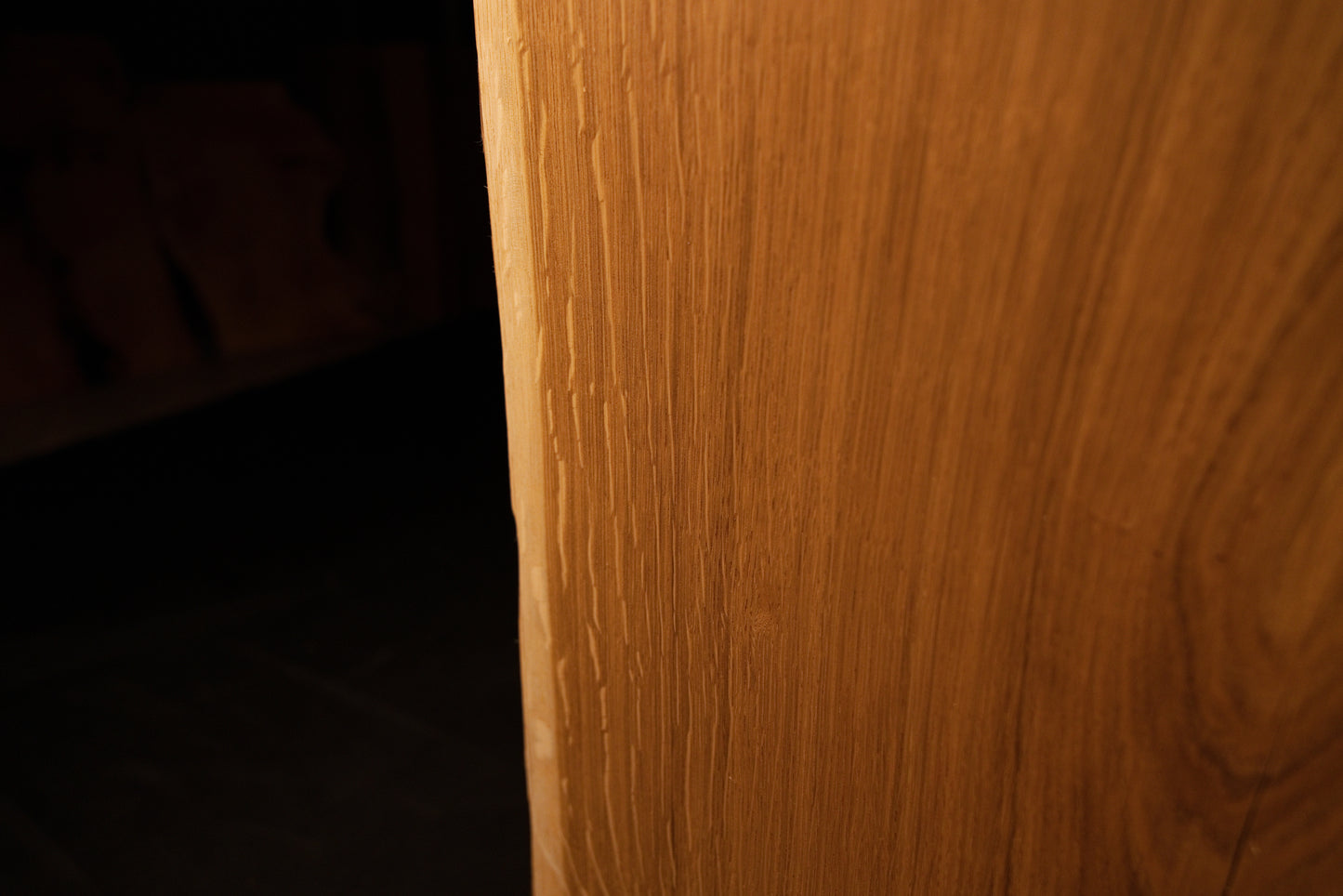 Macro perspective highlighting dense vertical wood fibers and rich golden tones on the face of the custom oak slab.