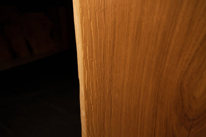 Macro perspective highlighting dense vertical wood fibers and rich golden tones on the face of the custom oak slab.