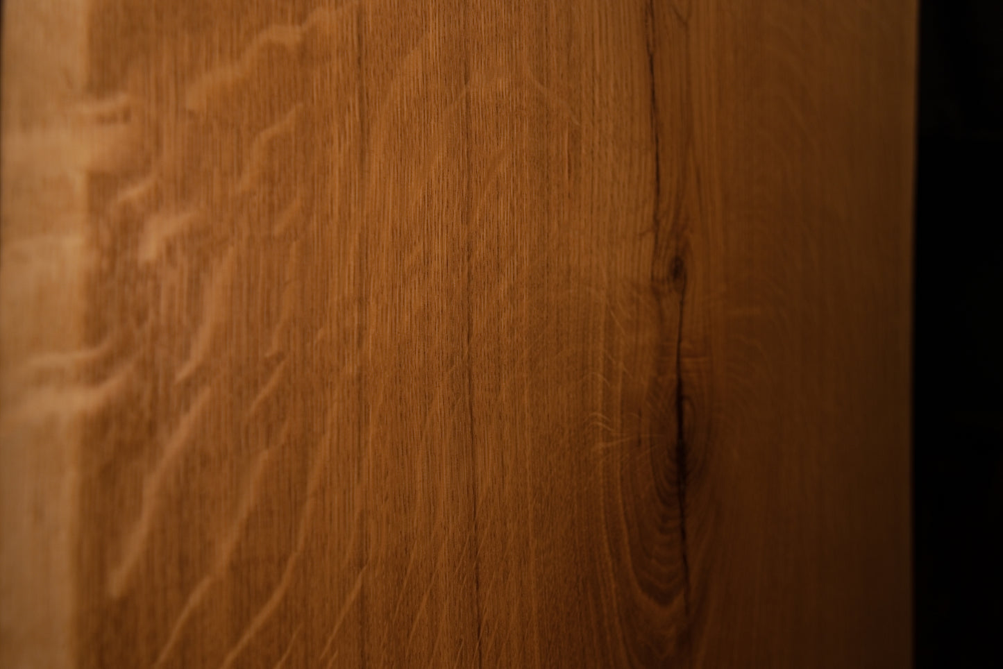 Macro close-up of vertical wood fibers and subtle grain variations along the polished outer edge of the solid custom oak board.