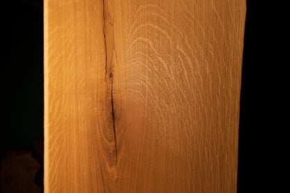 Straight vertical macro perspective of a tight natural fissure running through the highly figured grain of the custom oak board.