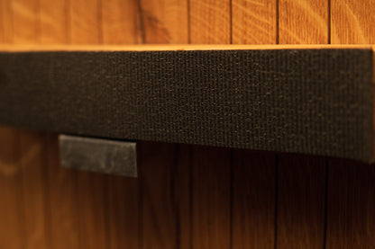 Detailed view of the central support bar wrapped in textured fabric and secured with a polished metal hardware clip. 