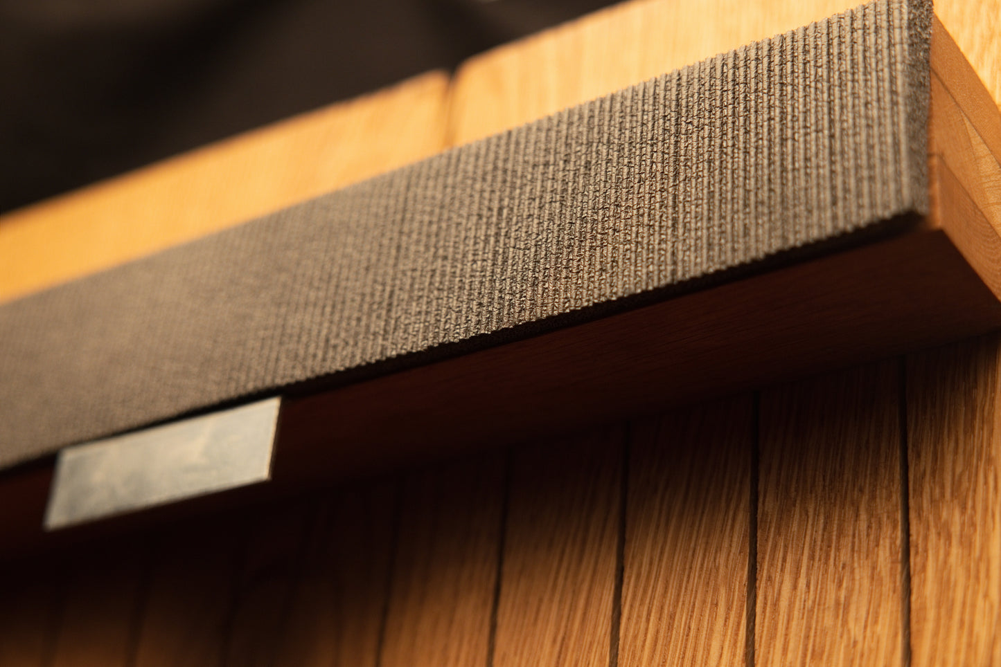 Macro perspective highlighting the durable woven fabric strap wrapped tightly around the horizontal wooden support bracket. 