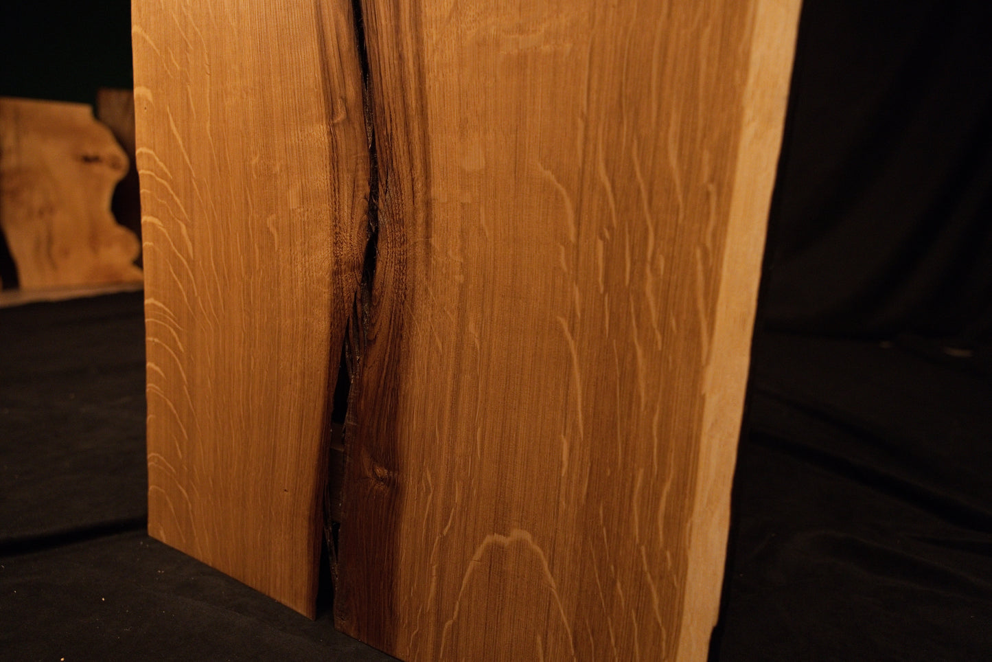 Close-up macro showing a natural wood knot splitting into a delicate fissure across the highly figured solid oak panel face. 