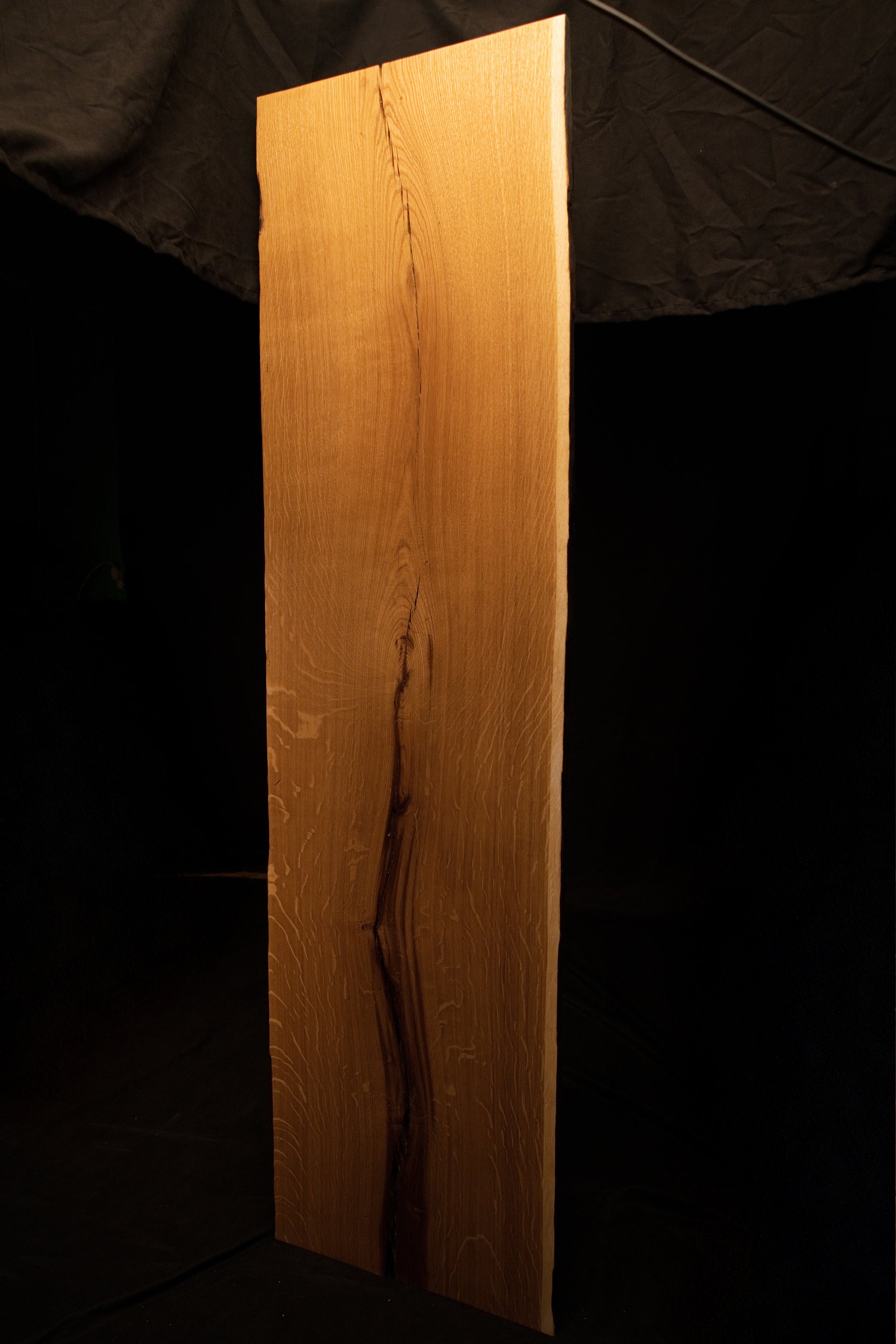 Full frontal elevation of the solid oak architectural panel featuring a dark central split and rich quartersawn wood textures. 