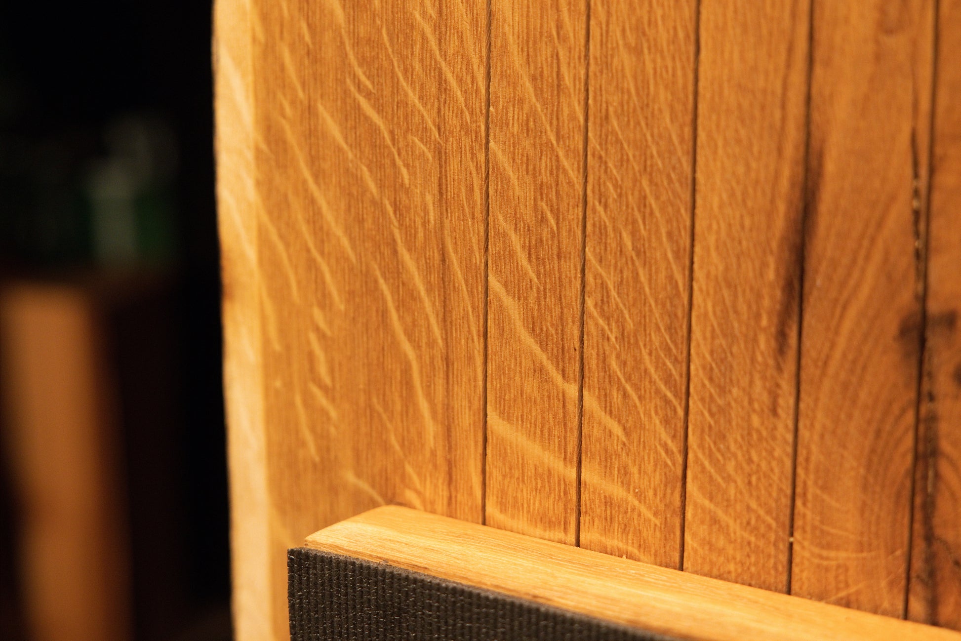 Macro perspective highlighting natural medullary ray figures running near the horizontal support bar on the oak board. 
