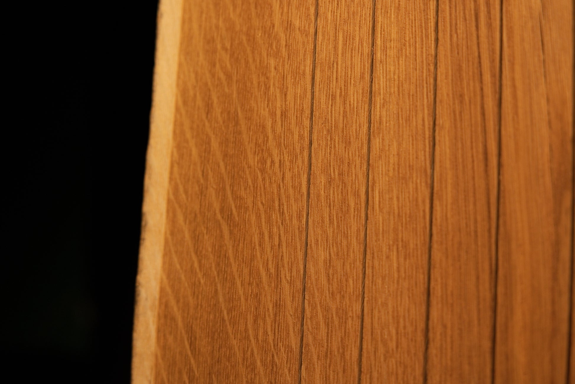 Detailed close-up showing uniform vertical wood slats and fine grain alignment across the face of the custom oak structure. 