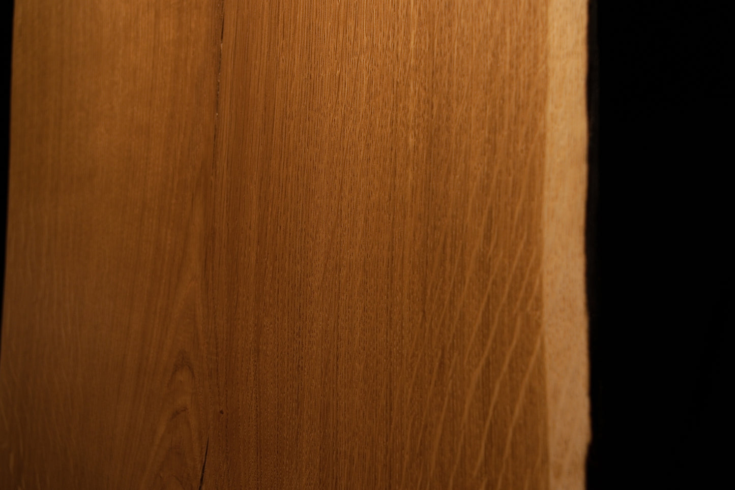 Detailed perspective highlighting warm amber wood textures and subtle medullary reflections near the right edge of the board. 