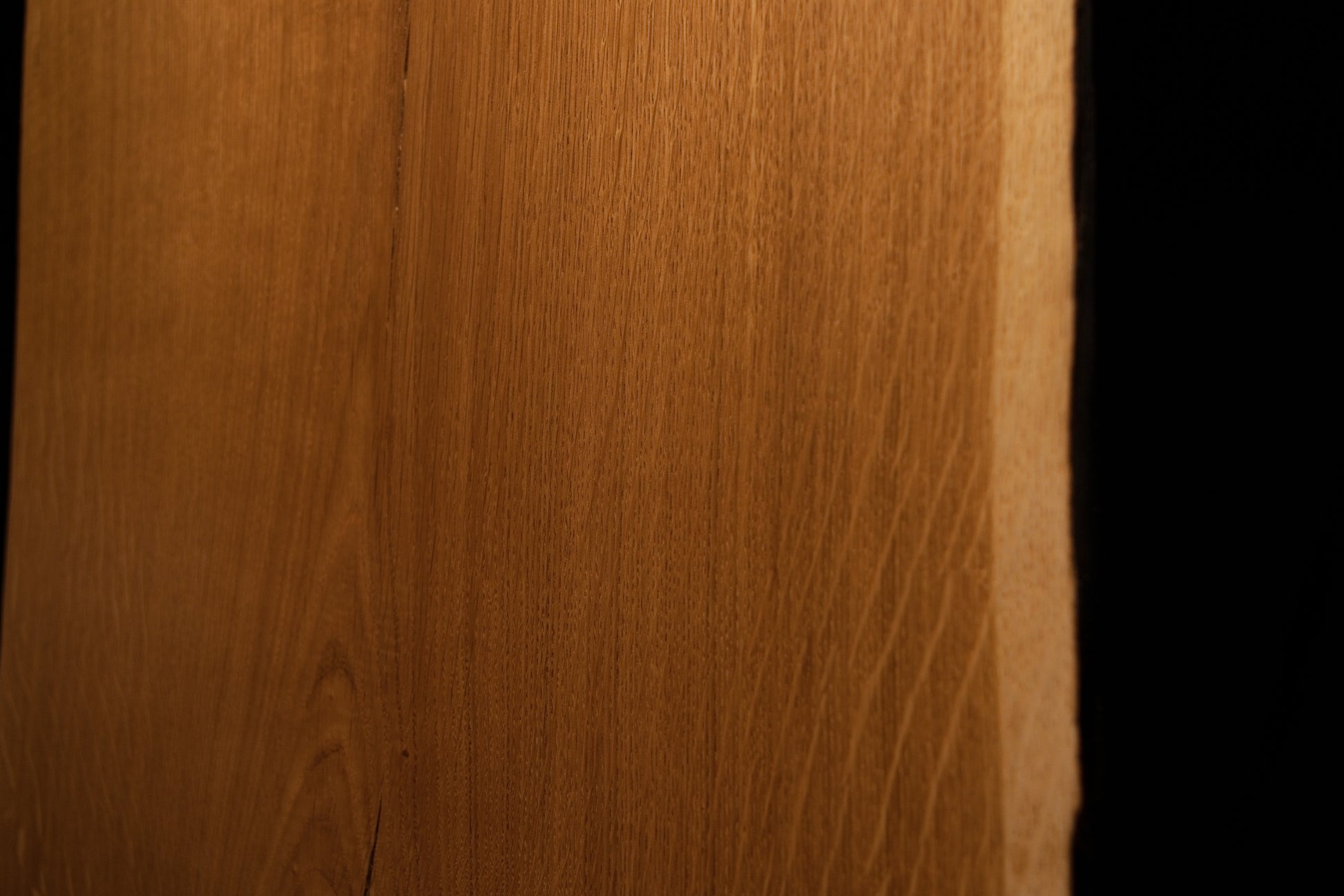 Detailed perspective highlighting warm amber wood textures and subtle medullary reflections near the right edge of the board. 