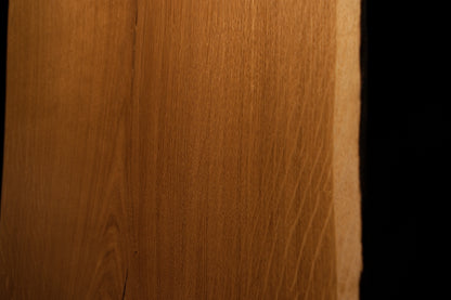 Detailed perspective highlighting warm amber wood textures and subtle medullary reflections near the right edge of the board. 