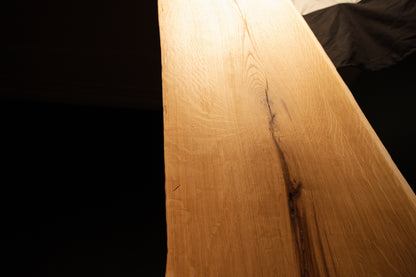 Macro photograph capturing soft studio lighting reflecting across the polished surface of the custom architectural oak panel. 