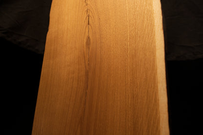 Close-up macro perspective of fine linear wood grain and smooth surface contours near the upper center of the oak board. 