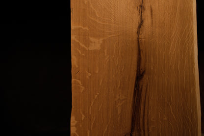 Detailed macro shot highlighting natural medullary ray patterns running alongside a dark fissure on the solid oak panel. 