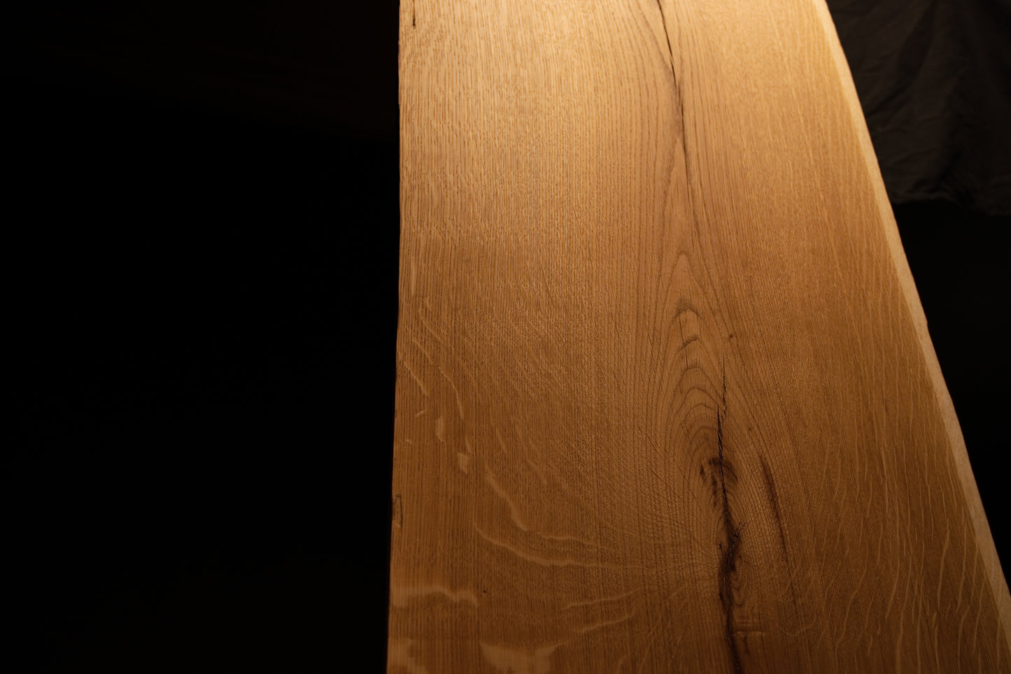 Detailed macro view of smooth wood textures and subtle color variations along the polished surface of the solid oak panel. 