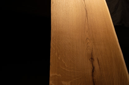 Detailed macro view of smooth wood textures and subtle color variations along the polished surface of the solid oak panel. 