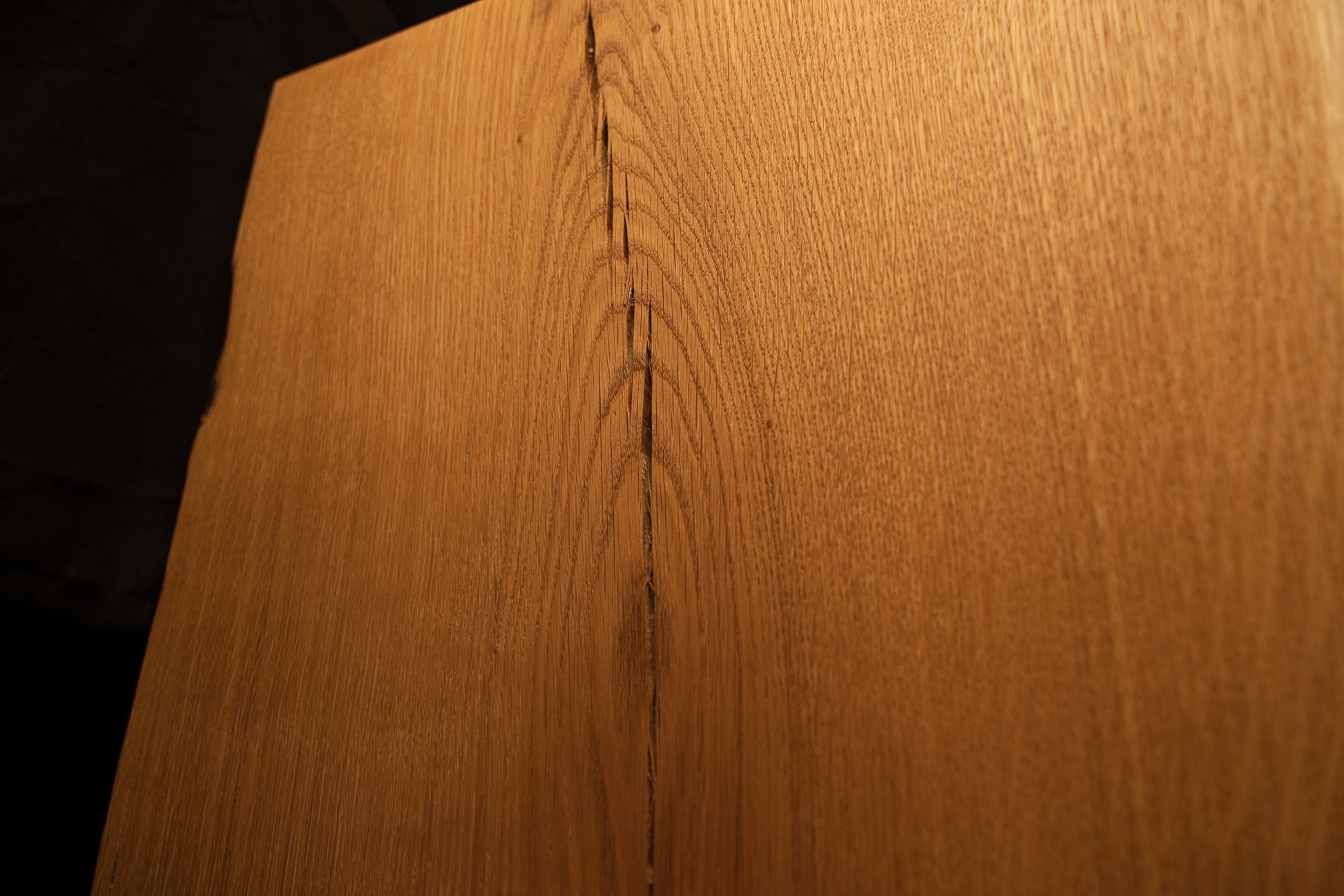 Macro view capturing the intricate convergence of grain lines and natural wood character at the top of the oak panel. 