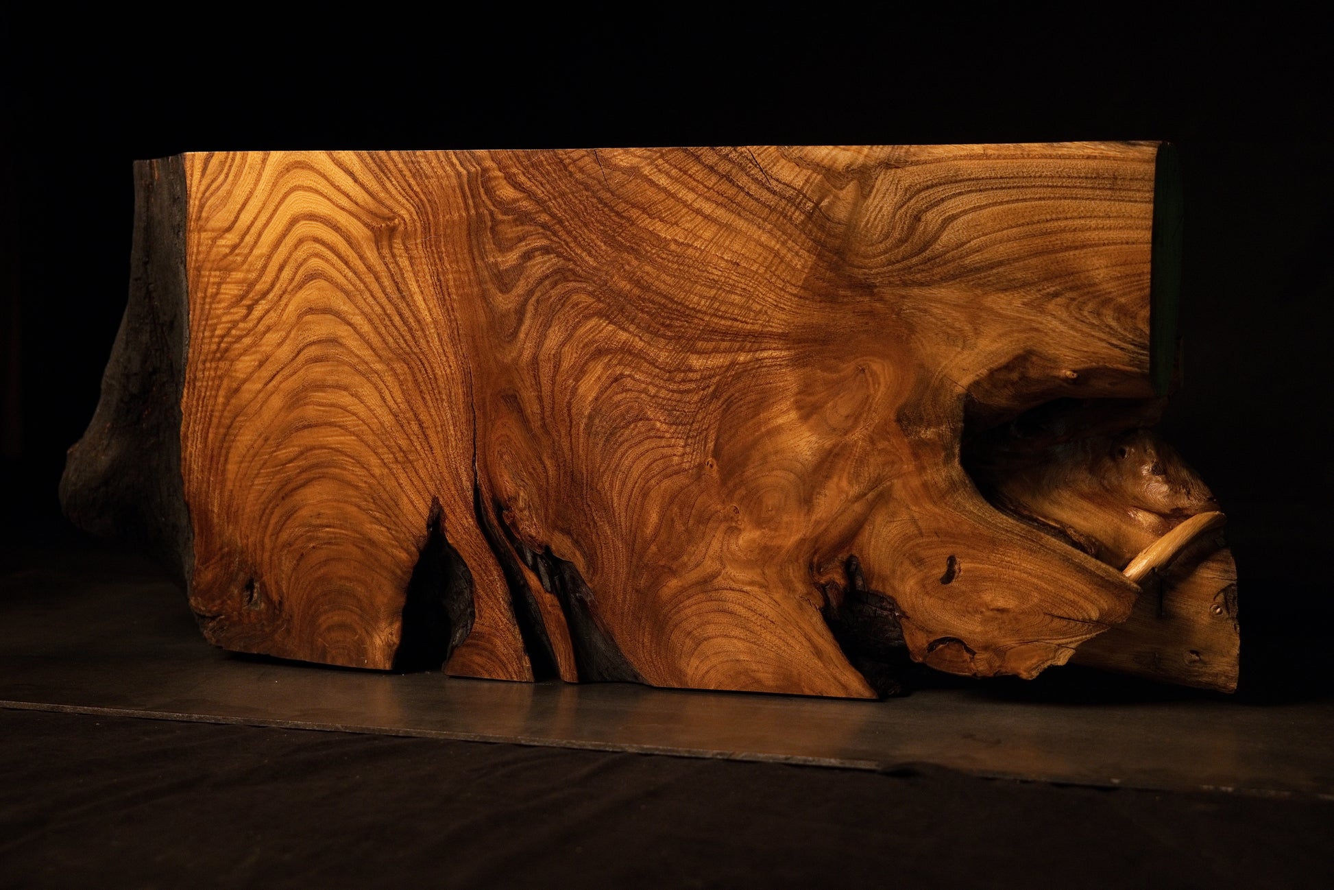 Side view of the large sculptural root element demonstrating fluid grain movement and organic structural transitions.  