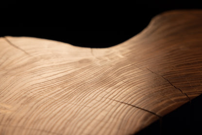 Close-up framing of a gently undulating wooden surface demonstrating seamless grain continuity and warm amber coloration. 