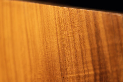 Fine-detail macro view of delicate linear wood texture running parallel near the polished top edge of the root sculpture. 