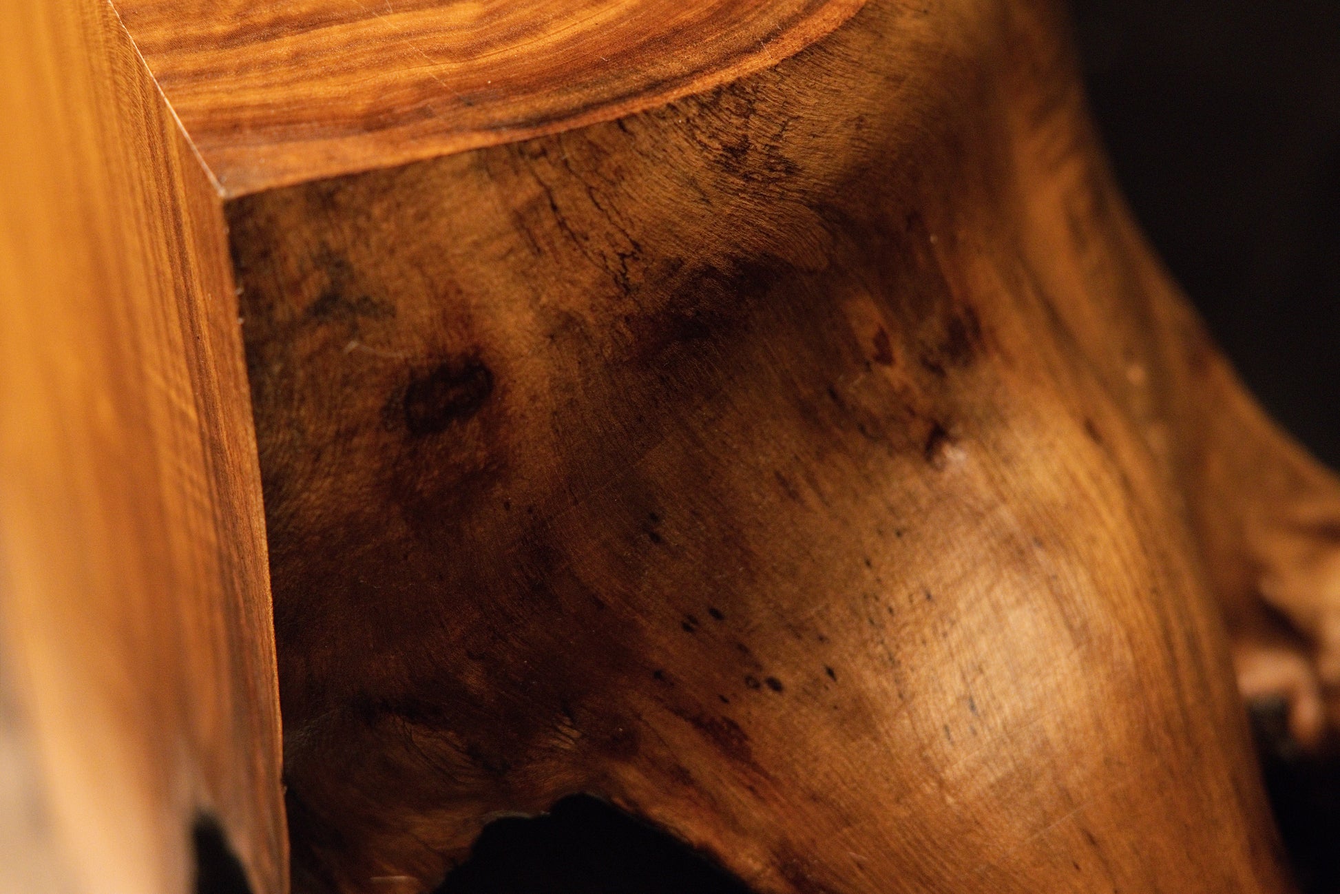 Perspective angle of a sharp wooden block corner emphasizing rich natural grain textures and small dark knot details. 