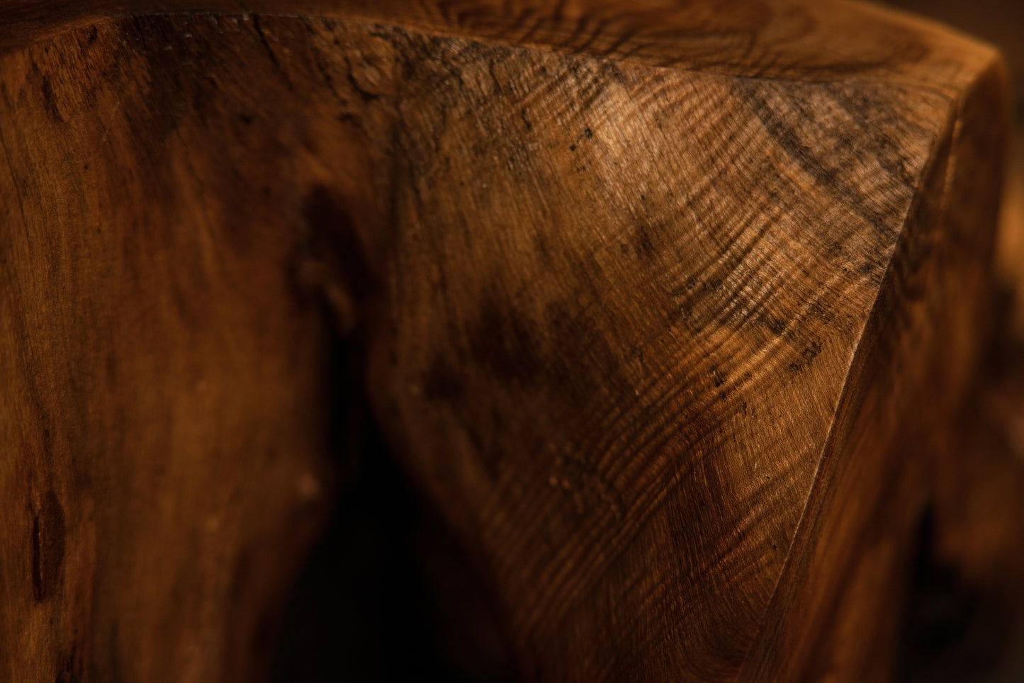 Close-up macro angle of a solid structural wooden block corner revealing intricate grain direction and warm coloration. 