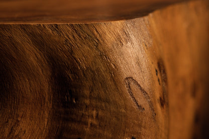 Close-up perspective of a polished wooden block edge exhibiting clean grain patterns and a subtle natural indent mark. 