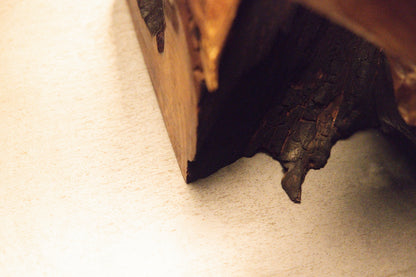 Close-up perspective of a solid structural wooden block corner revealing intricate grain direction and coloration. 