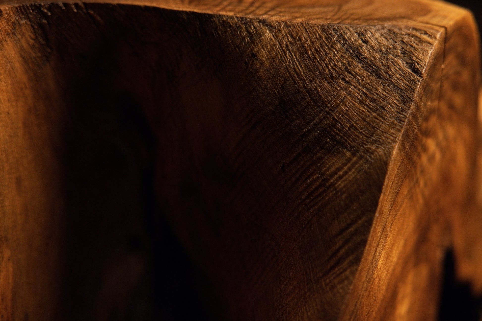 Detailed macro perspective of a solid structural wooden block corner showcasing rich warm grain tones and textures. 